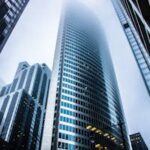 Dramatic view of modern skyscrapers shrouded in fog in an urban cityscape.